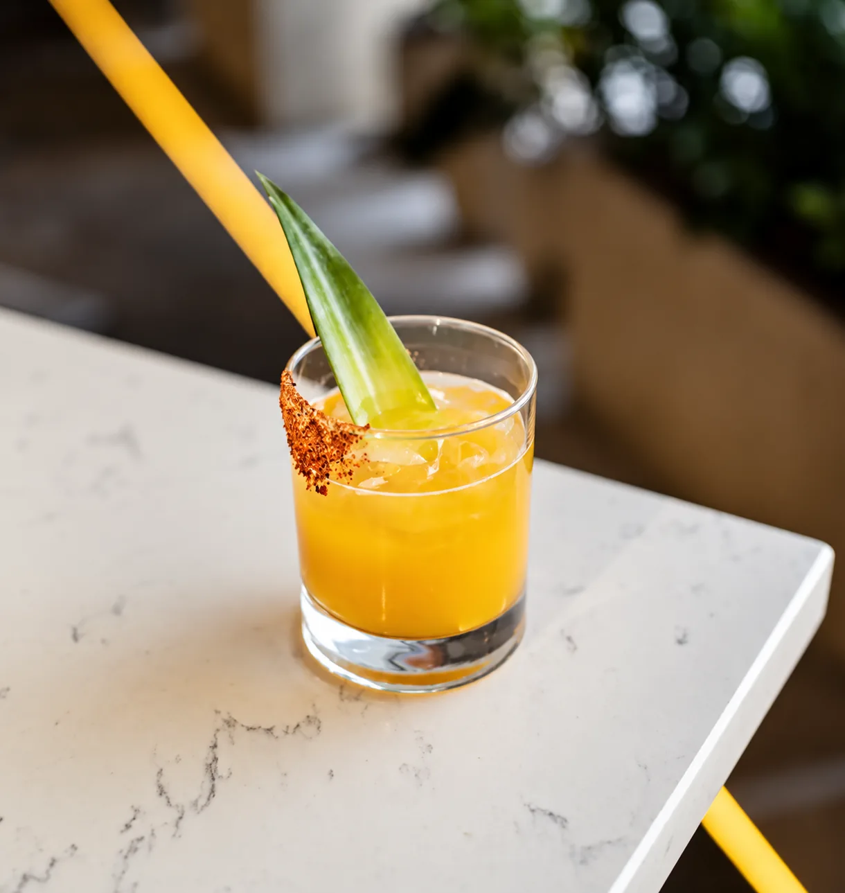 Golden cocktail with a seasoned rim at Kalypso Beach